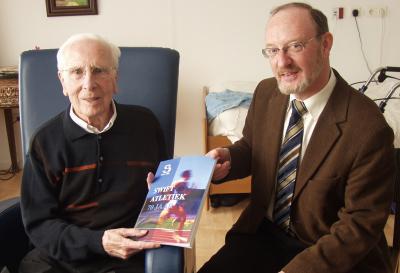 Peter Willemse tijden de uitreiking van zijn eerste exemplaar van het boek 70 jaar Swift Atletiek aan n van de oprichters van Swift Cor Lamboo